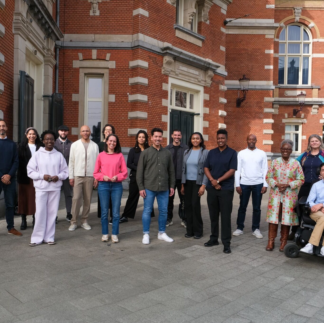 Group of colourful people standing in front of ITA as the kick-off for the traineeship ATANA