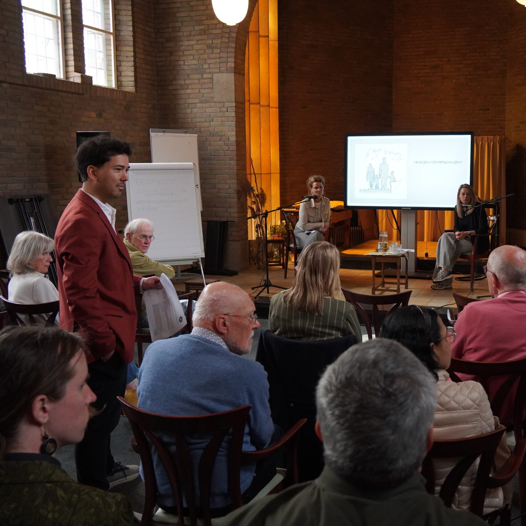 Joey Velberg staat in de zaal als moderator tijdens een event